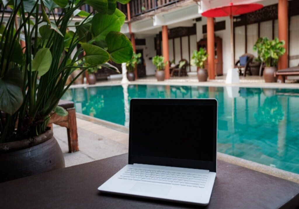 Laptop kept by pool on a table